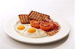 Petit déjeuner anglais (œuf sur le plat, bacon, pain de blé entier grillé, tomates)