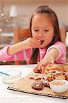 Une fille manger fraîchement cuit au four de Noël biscuits