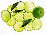 Un citron entier, tranche de citron vert et feuilles de lime