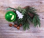 A sprig of pine with Christmas decoration on a wooden surface