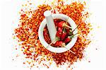 Dried chilli peppers and chilli flakes in a mortar