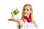 Blond female chef balancing fennel bulb on her hand