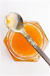 Apricot jam in a jar with a spoon (seen from above)