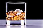 A glass of whisky with ice cubes