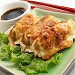 Three Potstickers with Chopsticks and Soy Sauce