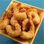 Battered Fried Shrimp in a Yellow Bowl on a Blue Background