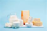 Various milk products (cheese, yoghurt, quark, milk) on a blue background