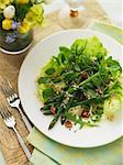 Ein gemischter Blattsalat mit grünem Spargel und Nüssen