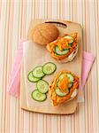 A chicken sandwich with cucumber and carrots