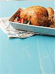 A whole roast chicken in a roasting tin