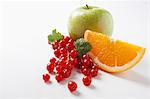 Redcurrants, an orange wedge and an apple