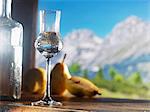 A glass of William's pear schnapps against an alpine backdrop