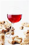 A glass of red wine with corks