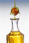 Hazel nut oil dropping from a hazel nut into a carafe