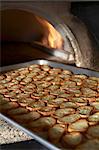 Baked Baguette Slices on a Sheet Pan Coming Out of a Pizza Oven