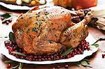 Whole Roast Turkey on a Platter with Cranberries and Bay Leaves