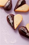 Heart-shaped biscuits decorated with chocolate icing and candied lavender flowers