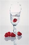 A raspberry falling into a schnapps glass