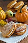 Deux secteurs de Whoopie de potiron avec le sucre en poudre ; Gourdes