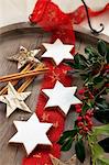 Cinnamon stars, sprigs of holly, cinnamon stick and wooden stars