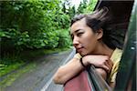 Jeune femme regardant par la fenêtre de voiture