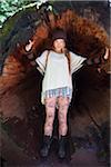 Young Woman Standing Inside Fallen Tree