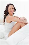 Gros plan d'une femme souriante assise dans son lit