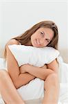 Young woman hugging a pillow