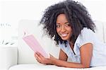 Portrait of a smiling brown woman reading a book