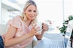 Portrait d'une blonde sur un ordinateur portable avec un café