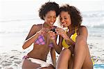 Young beautiful women in swimsuits looking at a digital camera