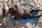 Overhead view of a young businessman lying on the beach