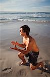 Jeune homme séduisant, jouant sur la plage