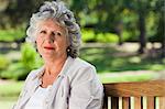 Old woman in a park sitting down