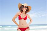 Woman in beachwear smiling with her hands on her hips