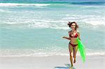 Woman in a bikini running while carrying a air bed