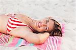 Woman smiling while sunbathing on a beach