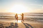 Four friends running out of the water with the horizon in the background