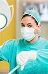 Female surgeon performing while looking at camera