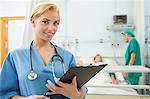 Blonde nurse holding a chart while looking at camera