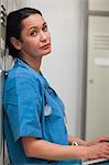 Female surgeon sitting in a locker room with a laptop