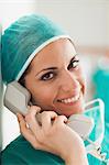 Female surgeon smiling on the phone in a hallway