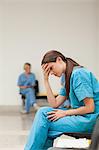 Sad nurse with a clipboard while sitting in a waiting room