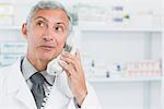 Pharmacist in a pharmacy while phoning