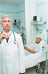 Serious doctor with a syringe in his hands in a room