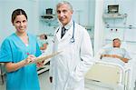 Infirmière et médecin à la recherche de fichiers dans un hôpital avec deux patients souriant