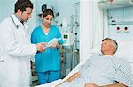 Doctor and nurse looking at a paper with a patient