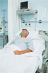 Patient couché sur un lit avec un masque à oxygène