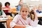 Smiling girl sitting at desk in classroom