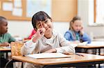 Girl scratching her forehead with pen